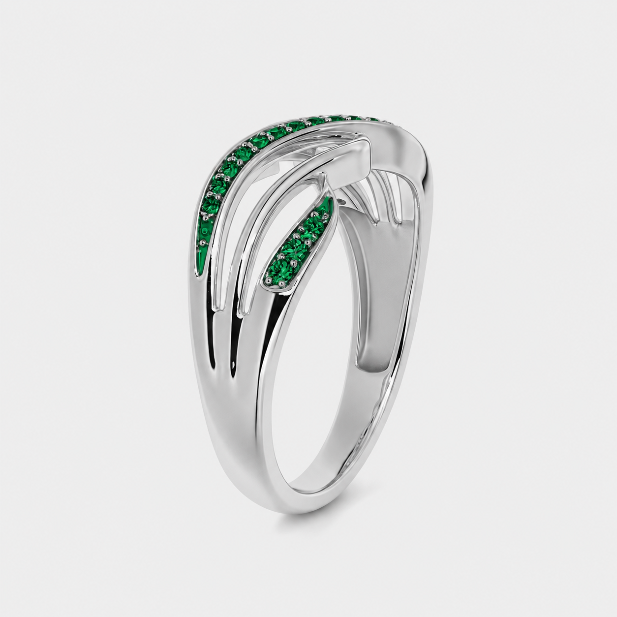 Angled view of silver-tone openwork ring with emerald green cubic zirconia detailing