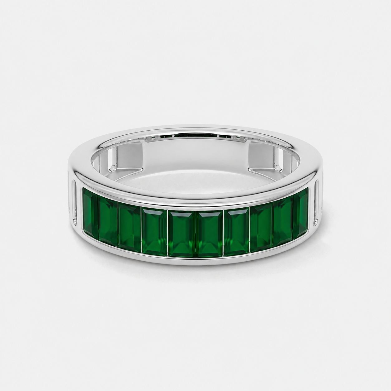 Close-up view of emerald green baguette cubic zirconia band ring with polished silver-tone finish