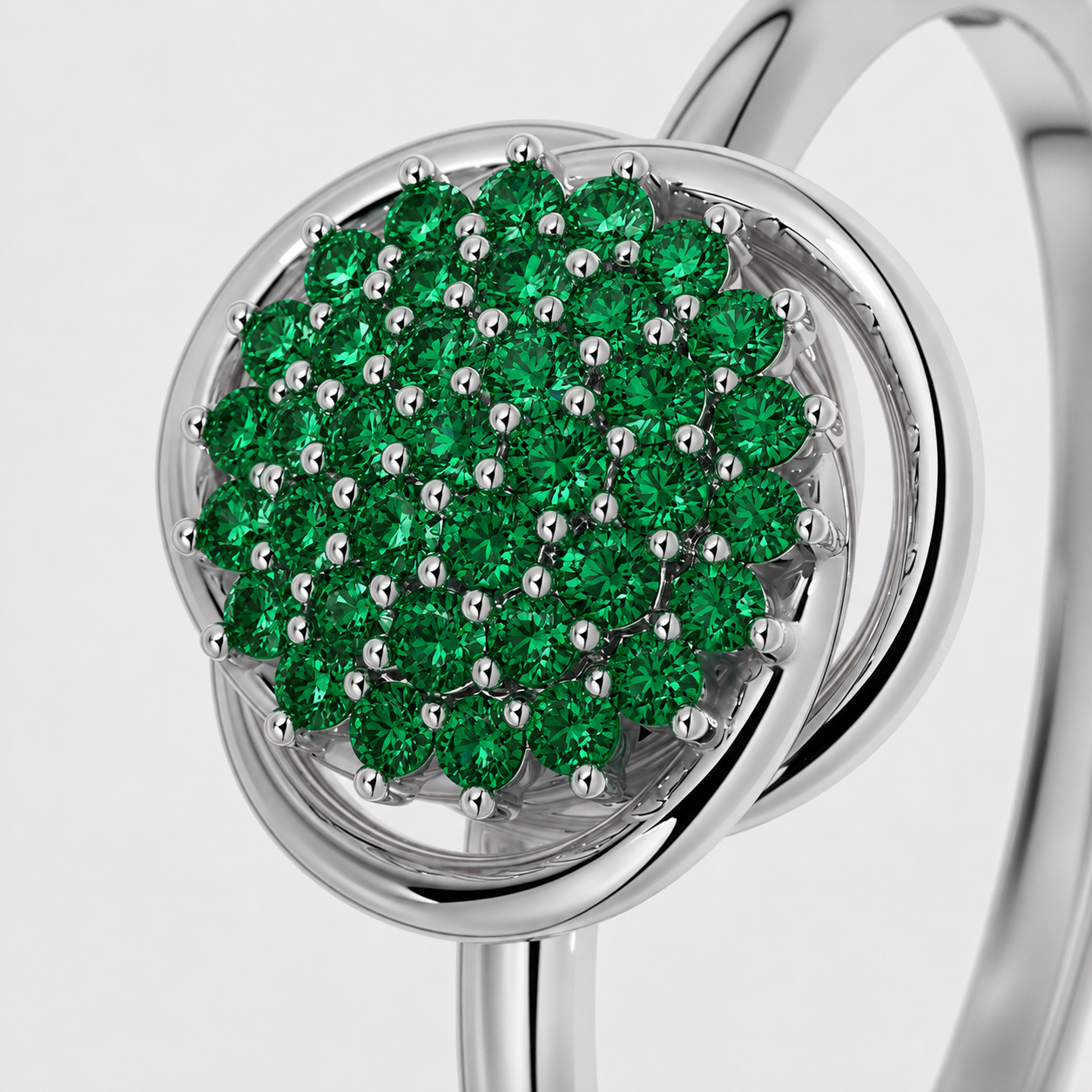 Close-up view of silver-tone ring featuring a round cluster of emerald green cubic zirconia stones