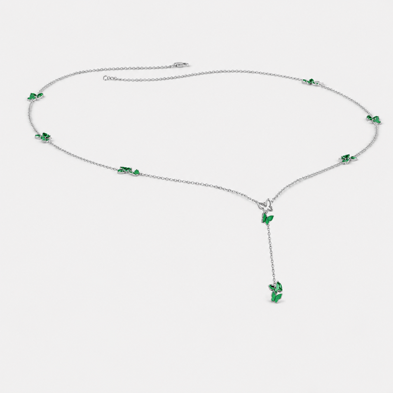 Front view of silver-tone Y-drop necklace featuring emerald green butterfly-inspired cubic zirconia accents and dangling pendant detail