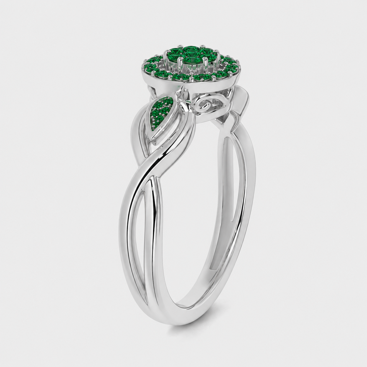 Side angle view of silver-tone floral halo ring featuring emerald green cubic zirconia stones and leaf-inspired accents