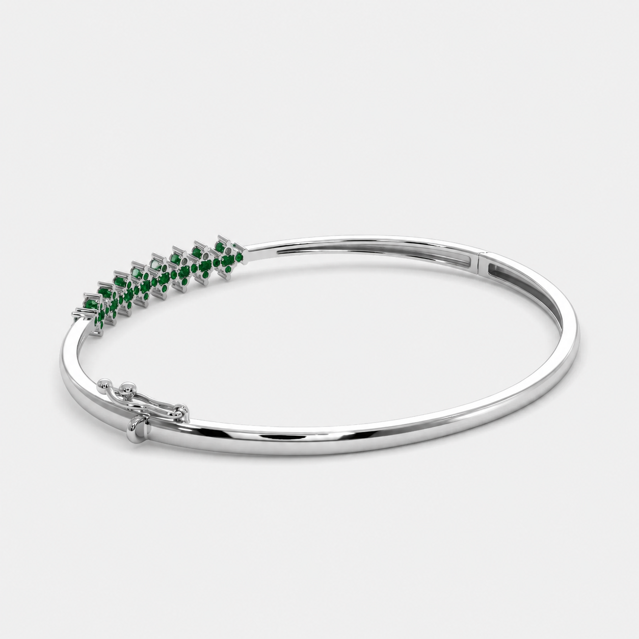 Side perspective of silver-tone bracelet showcasing emerald green marquise-cut stone detailing