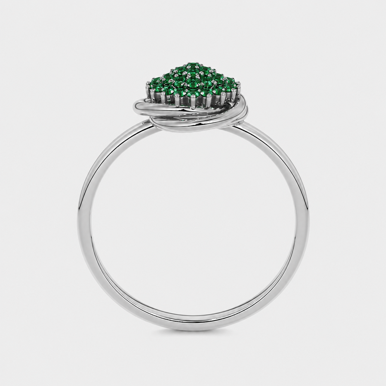 Side profile of silver-tone ring showcasing raised emerald green cubic zirconia setting