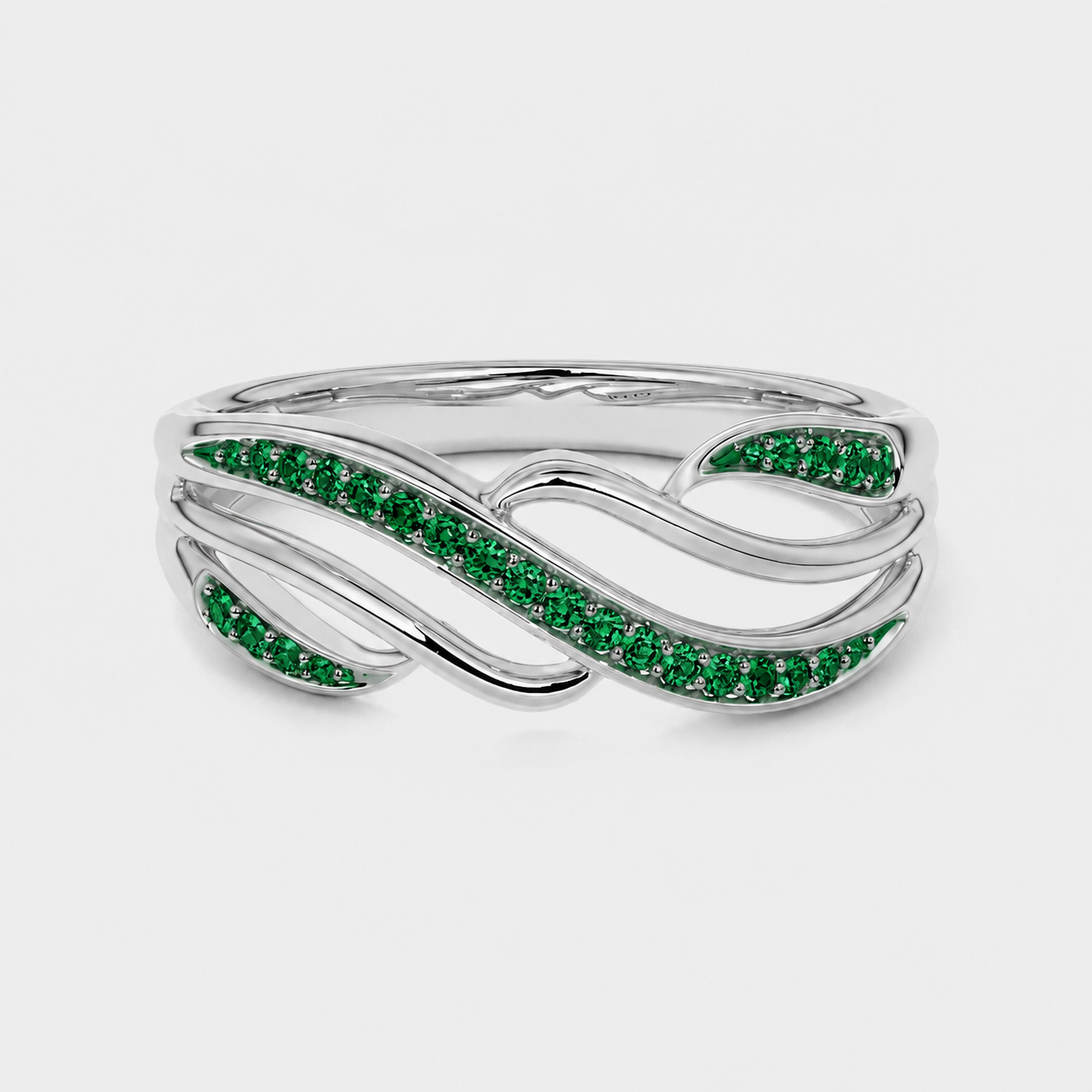 Top view of silver-tone ring showcasing flowing leaf-inspired design with emerald green stones
