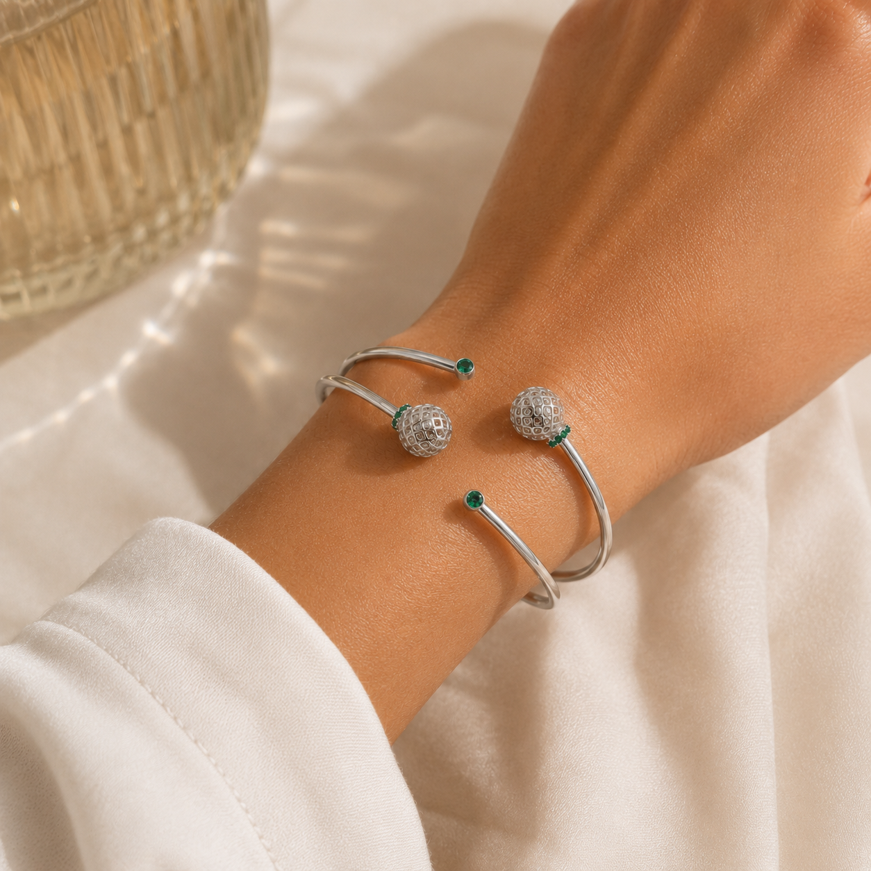 Woman wearing a silver-tone double band cuff bracelet with openwork sphere accents on the wrist