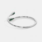 Side perspective of silver-tone open bracelet showcasing emerald green pavé cubic