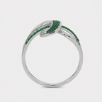 Angled view of silver-tone abstract swirl ring with emerald green stone accents