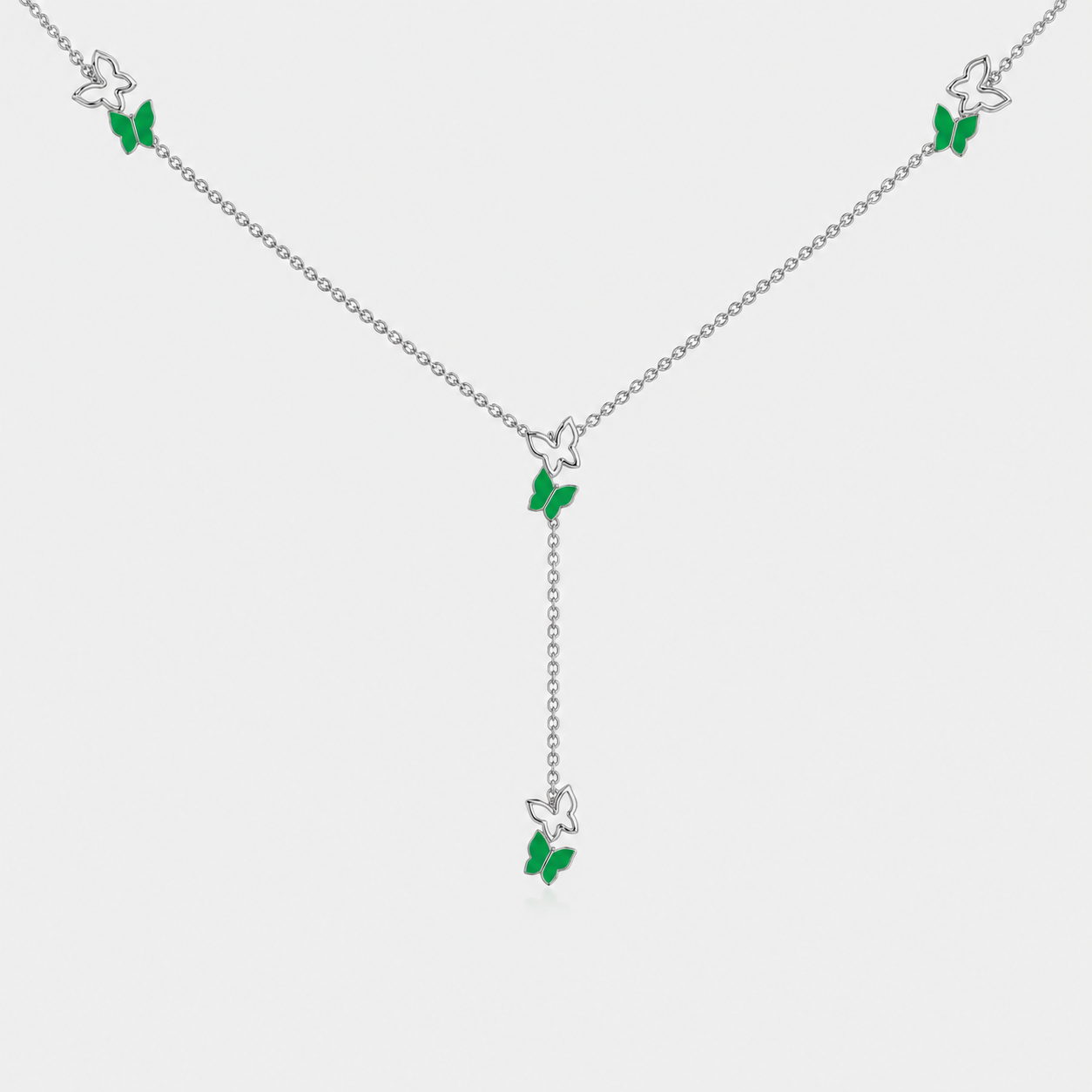 Angled view of silver-tone butterfly station necklace with emerald green gemstone-inspired accents and adjustable chain