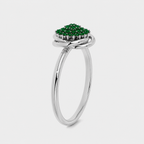 Angled view of silver-tone floral-inspired cluster ring with emerald green stone accents and polished finish