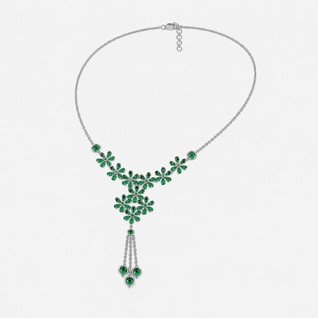 Angled view of silver-tone floral necklace with emerald green gemstone-inspired details and decorative tassel centerpiece