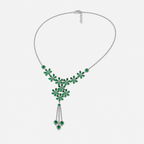 Angled view of silver-tone floral necklace with emerald green gemstone-inspired details and decorative tassel centerpiece