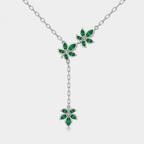 Angled view of silver-tone floral station necklace with multiple emerald green gemstone-inspired details and adjustable chain