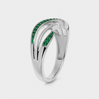 Angled view of silver-tone openwork ring with emerald green cubic zirconia detailing