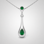Close-up view of emerald green teardrop pendant suspended from a fine silver-tone chain