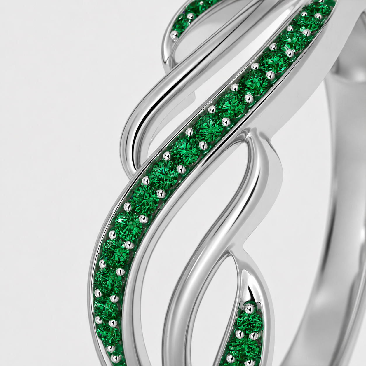 Close-up view of silver-tone leaf vine ring featuring emerald green cubic zirconia accents