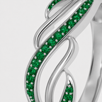Close-up view of silver-tone leaf vine ring featuring emerald green cubic zirconia accents