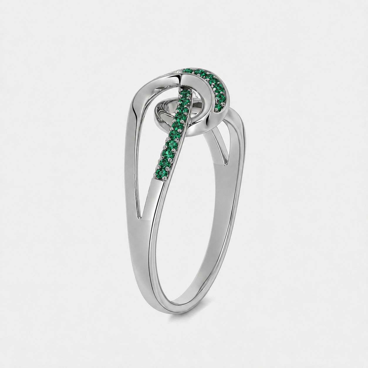 Close-up view of silver-tone openwork ring showcasing emerald green cubic zirconia detailing and polished finish