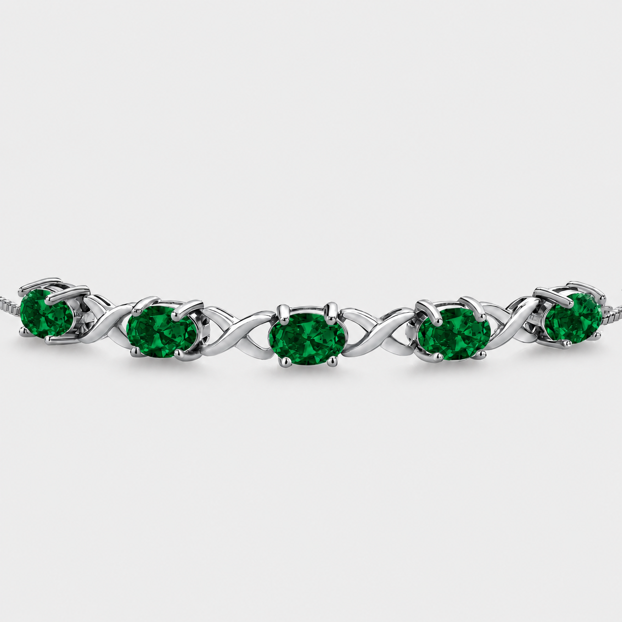 Emerald green oval cubic zirconia adjustable tennis bracelet with silver-tone infinity link design