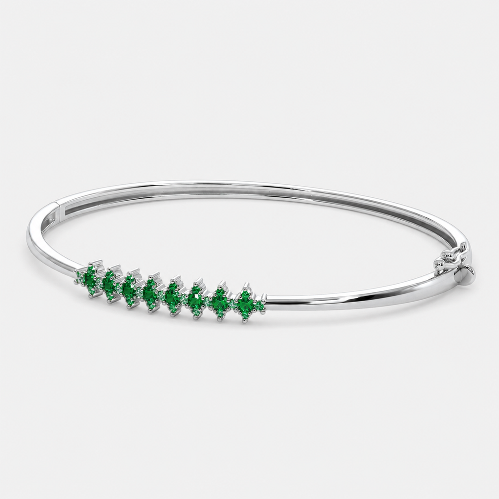 Front view of silver-tone bangle bracelet featuring emerald green marquise-cut cubic zirconia accents