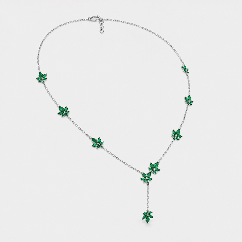 Front view of silver-tone station necklace featuring emerald green floral cubic zirconia accents and drop pendant design