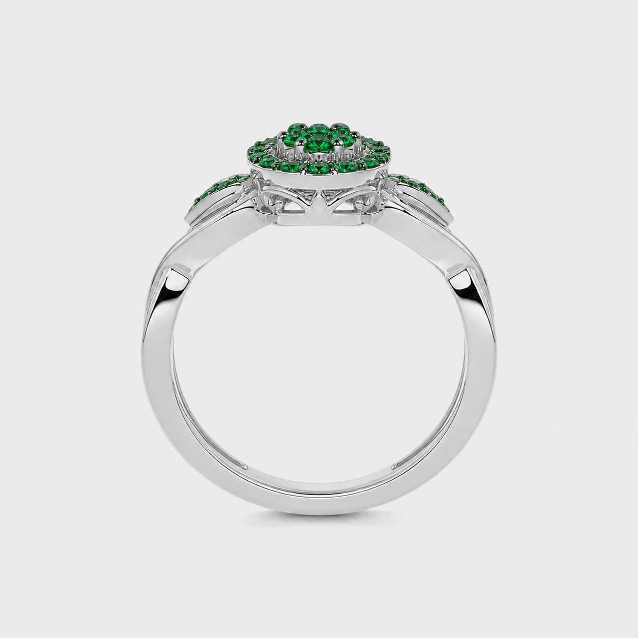 Profile view of silver-tone ring with raised emerald green floral cluster centerpiece and polished band