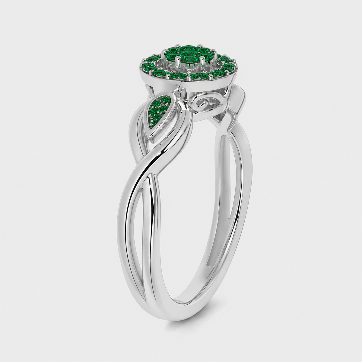 Side angle view of silver-tone floral halo ring featuring emerald green cubic zirconia stones and leaf-inspired accents