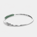 Side perspective of silver-tone bracelet showcasing emerald green marquise-cut stone detailing
