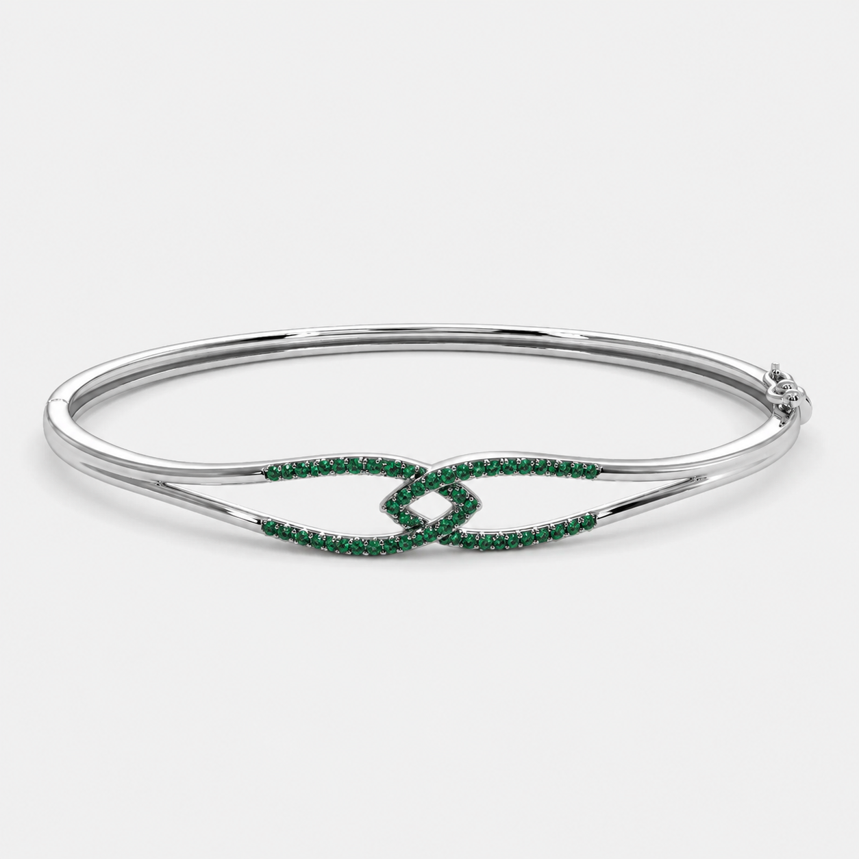 Side perspective of silver-tone open bracelet showcasing emerald green pavé cubic zirconia ends