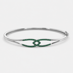 Side perspective of silver-tone open bracelet showcasing emerald green pavé cubic zirconia ends