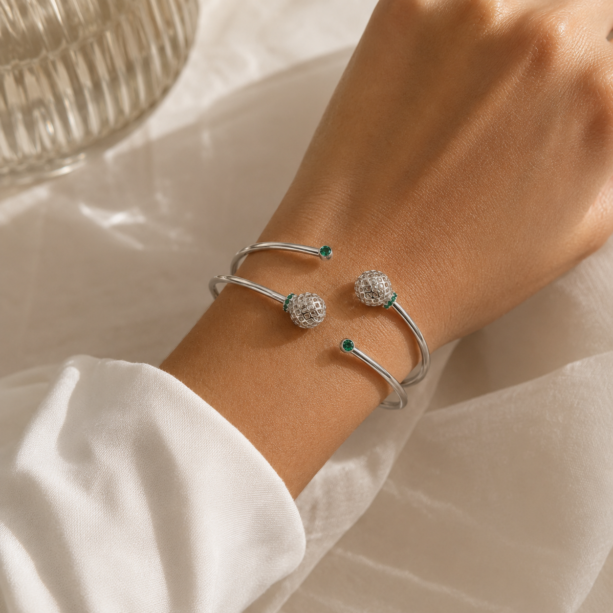 Side perspective of silver-tone open cuff bracelet showcasing decorative sphere details and polished finish