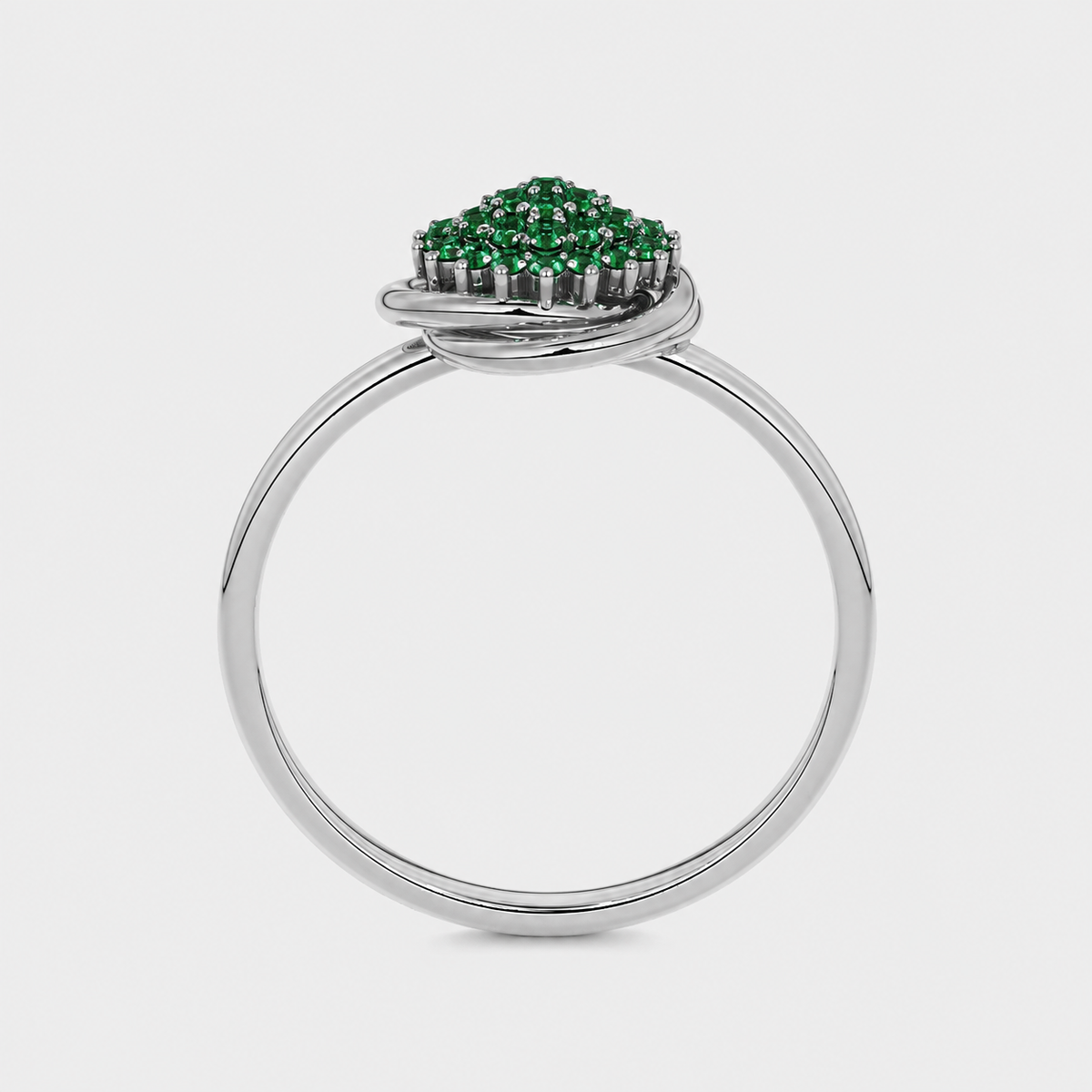 Side profile of silver-tone ring showcasing raised emerald green cubic zirconia setting