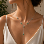 Silver-tone butterfly Y-drop necklace worn around the neck featuring emerald green cubic zirconia accents and elegant drop pendant
