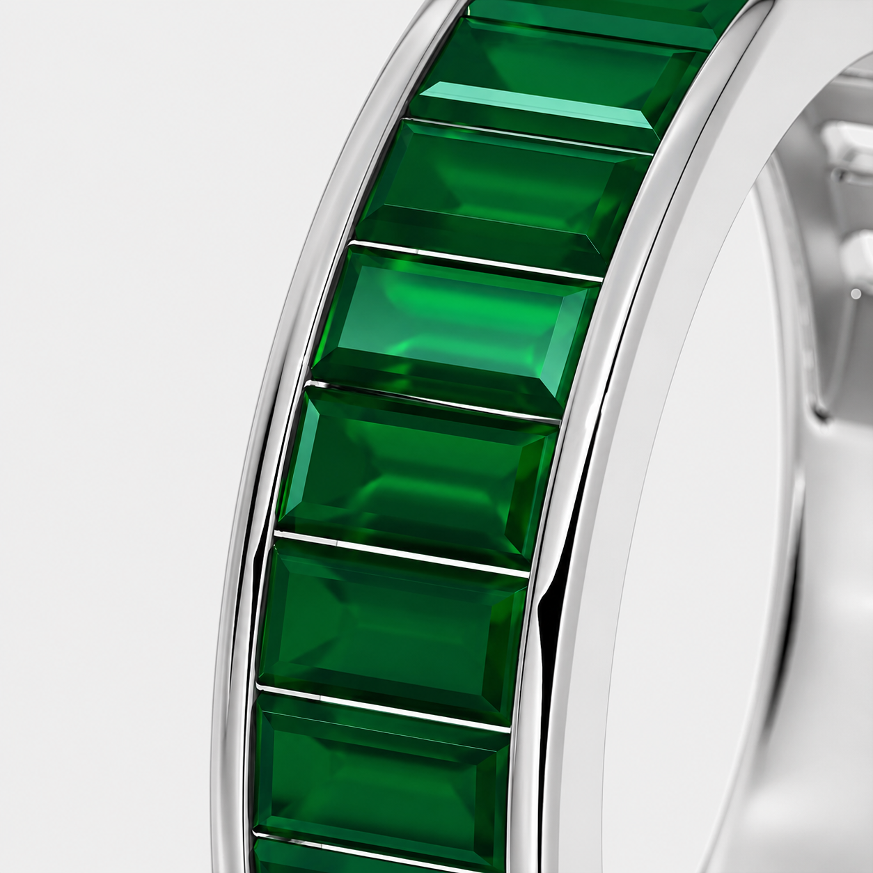Silver-tone ring featuring emerald green baguette-cut cubic zirconia stones in geometric channel setting