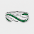 Top view of silver-tone ring showcasing flowing leaf-inspired design with emerald green stones